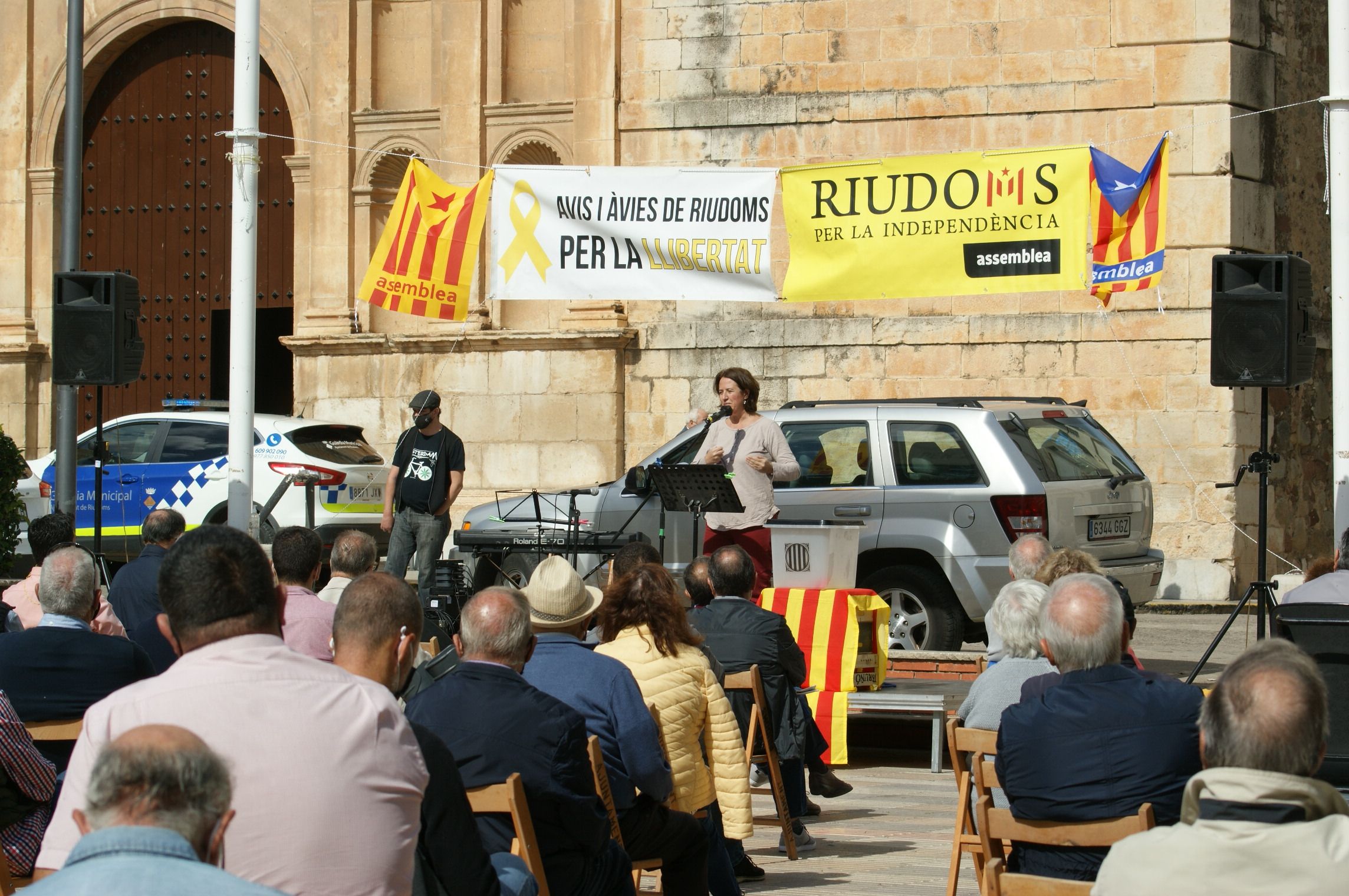 Elisenda Paluzie parlant davant del públic a la Plaça de l'Església